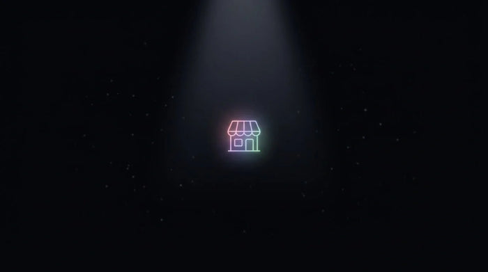 A single glowing storefront point drawn out of the dark by a converging beam of light, illustrating a store being surfaced by AI shopping on Black Friday
