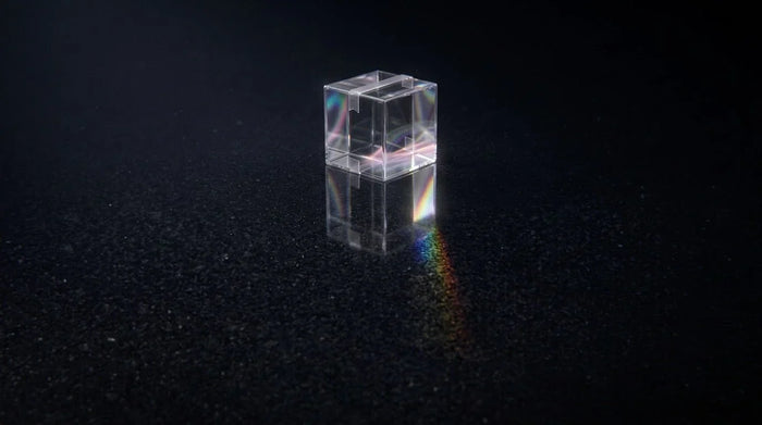 Translucent liquid-glass shipping box glowing on a dark background, representing 2026 holiday shipping cutoff deadlines for Shopify stores