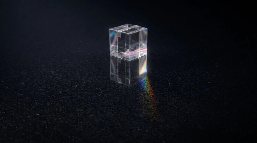 Translucent liquid-glass shipping box glowing on a dark background, representing 2026 holiday shipping cutoff deadlines for Shopify stores